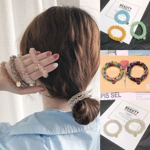 Detail of colorful beaded spiral hair ties with metallic charms and high-elasticity texture