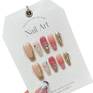 Handmade gradient pink press-on nails with gold edges, pearls, and 3D heart gems