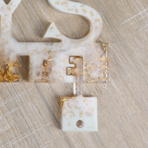 Makrodetail des Epoxidharz-Schlüsselregals mit Goldflocken und weißer Marmortextur