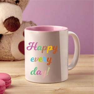 Detail of white ceramic mug with pink interior and rainbow Happy Every Day text