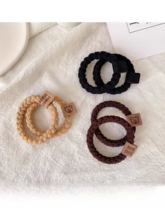 Detailed view of elastic knitted hair ties with leather teddy bear and handmade tags