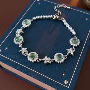 Bracelet élégant en argent avec pierres vertes et étoiles sur fond bleu foncé