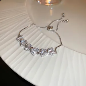 Adjustable silver bow bracelet with heart-shaped cubic zirconia and bolo slider clasp