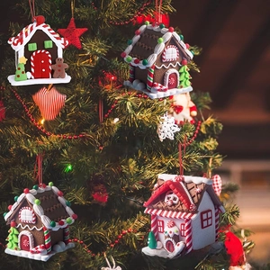 Close-up of four cute gingerbread house ornaments with sugar details on a Christmas tree