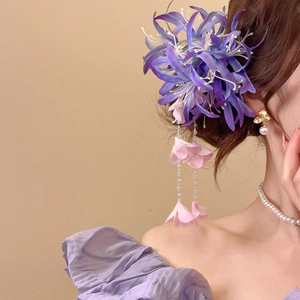 Détail de la pince à cheveux fleur en tissu violet avec longs glands et pendentifs