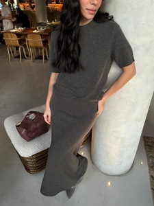 Detail of elegant dark grey knit set showing texture of short-sleeve top and skirt