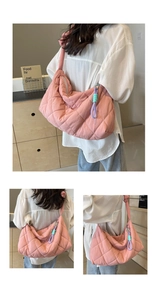 Detailed macro view of pink quilted puffer tote bag with decorative colorful braided charm