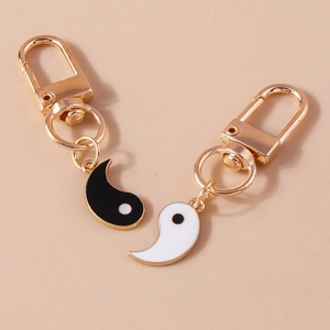 Detail view of black and white Yin Yang Tai Chi pendants with gold-tone hardware