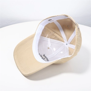 Detailed interior of khaki cotton baseball cap showing stitching and 100% cotton label