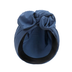 Detail eines graublauen Turban-Huts mit Schleifen-Design aus weichem Strickmaterial