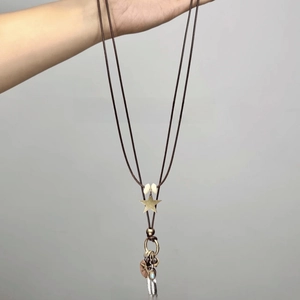 Detail of bohemian necklace with metal stars, feathers, and blue resin beads on cord