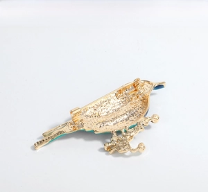 Detailed view of the golden bird brooch backside showing secure safety pin mechanism
