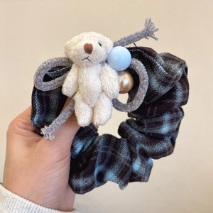 Close-up of checkered scrunchie with plush teddy bear and blue bead charms details