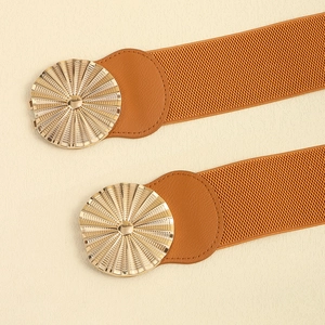 Detail of brown elastic waist belts featuring gold circular sunburst metal buckles