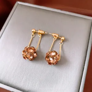 Vintage style gold drop earrings with champagne crystal sphere charms on grey box