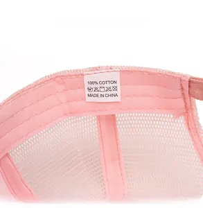 Dettaglio interno del cappellino rosa con etichetta 100% cotone e tessuto a rete traspirante