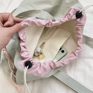 Macro view of canvas tote bag with pink drawstring closure and secure inner zip pocket