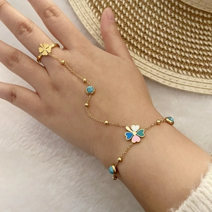 Détail du bracelet bague trèfle en émail et turquoise sur chaîne en acier doré