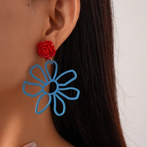 Boucles d'oreilles rose rouge en résine et grande fleur bleue ajourée sur modèle