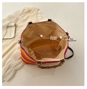 Detail view of woven straw tote bag with bamboo handle, leather strap, and internal pockets