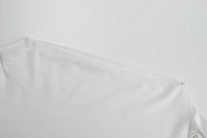 Détail d'une robe blanche à épaule dénudée avec tissu lisse et coutures d'épaule nettes