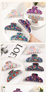 Detailed macro view of large floral acetate hair claw clips with vintage pattern designs