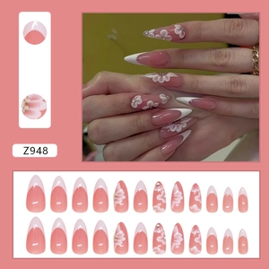French tip almond press-on nails with 3D floral accents and small rhinestones