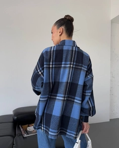 Back view of a long-sleeved plaid shirt for women featuring blue and black checkered patterns