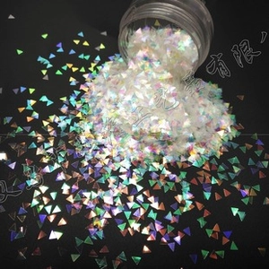 Macro shot of 3mm triangular iridescent laser sequins for nail art and DIY projects