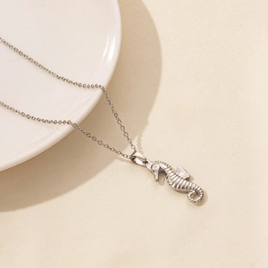 Detailed view of silver seahorse pendant with ocean texture on a minimalist chain