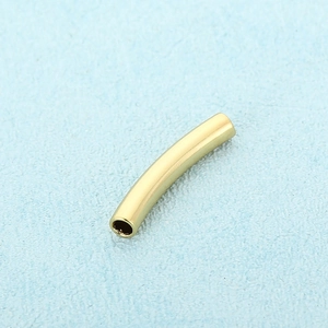 Macro shot of a curved hollow gold stainless steel tube connector for DIY jewelry making