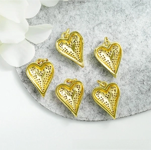 Detail view of heart-shaped 18K gold-plated pendants with honeycomb镂空 backing