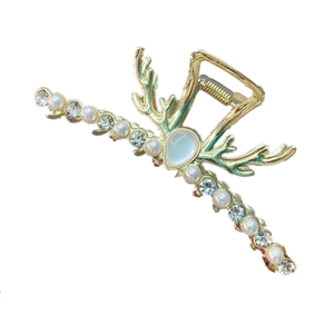 Dettaglio della molletta dorata con perle, strass e opale blu dallo stile raffinato