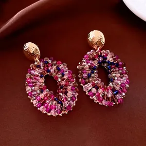 Luxurious oval beaded earrings with gold hammered finish and colorful faceted glass beads