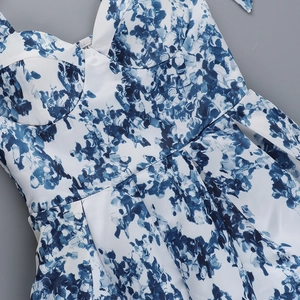 Détail d'une robe d'été à fleurs bleues et blanches avec taille ajustée et tissu tissé