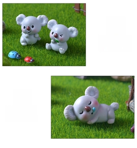 Detailansicht der Miniatur-Koala-Figuren aus Harz auf Kunstrasen für DIY-Dekoration
