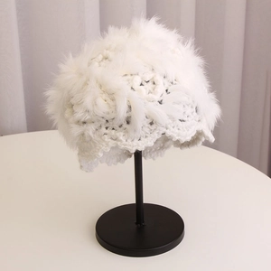 Detailed texture of white crochet rabbit fur knit hat on a black display stand