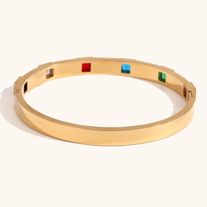 Detail of gold chain bracelet featuring square multi-color gemstones and spring clasp