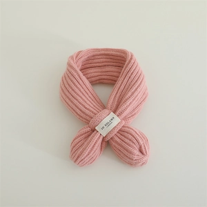 Close-up of pink chunky knit baby scarf showing soft texture and woven label detail