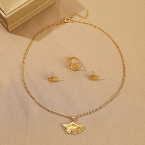 Detail view of gold ginkgo leaf jewelry set including necklace ring and earrings