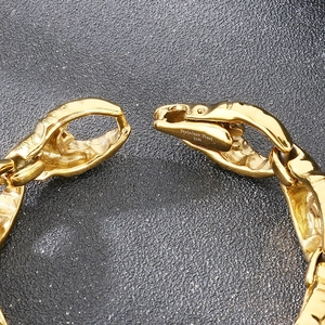 Detail of gold-tone 316L stainless steel bracelet with industrial crab claw link design