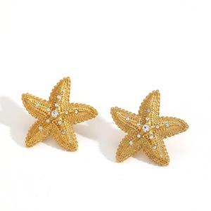 Starfish gold earrings with sparkling crystals and a central diamond on white background