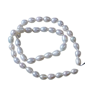 Strand of 5-6mm natural freshwater rice pearls with high luster on a white background