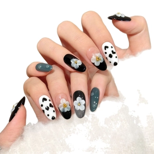 Handmade cow print press-on nails with white 3D flowers and heart patterns on long oval tips