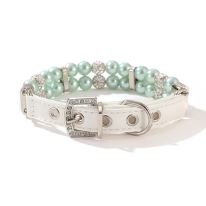 Macro shot of mint green double-row pearls and sparkling rhinestone buckle on pet collar