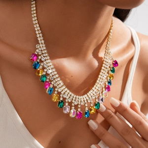 Detail of luxury geometric sweater necklace with colorful stones on female model