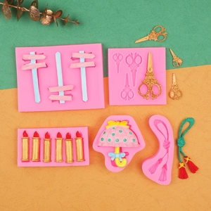 Pink silicone fondant molds featuring scissors, signpost, candle, and tassel designs