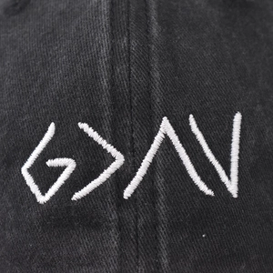 Washed black denim baseball cap with white embroidered geometric lettering and symbols