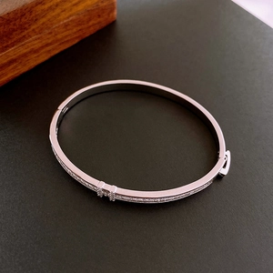 Detailed view of silver-tone thin bangle featuring a sparkling cubic zirconia H clasp