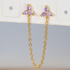 Macro detail of gold flower ear cuff with purple cubic zirconia and dangling chain